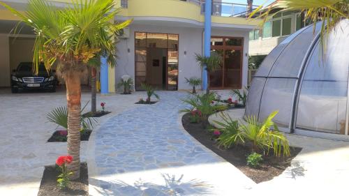 a house with a palm tree in front of it at Spa Hotel Montefila in Ulcinj