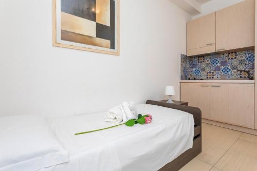 a bedroom with a white bed with a flower on it at Sirina Tao Beach in Taormina