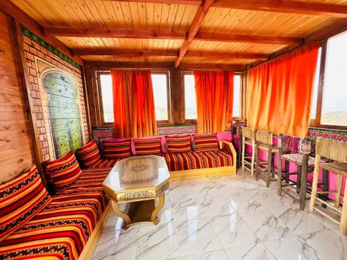 a room with couches and a table and windows at Happy Monkey Villa Taghazout in Aït Ahmed