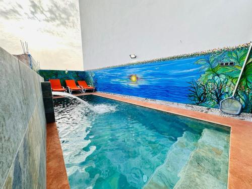 a swimming pool in a house with a painting on the wall at Happy Monkey Villa Taghazout in Aït Ahmed