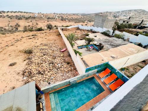 a house with a swimming pool in the desert at Happy Monkey Villa Taghazout in Aït Ahmed