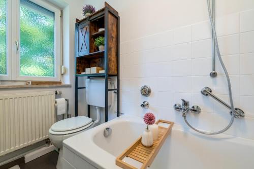 a bathroom with a white tub and a toilet at EG M City Wohnung nähe Salzburg in Freilassing