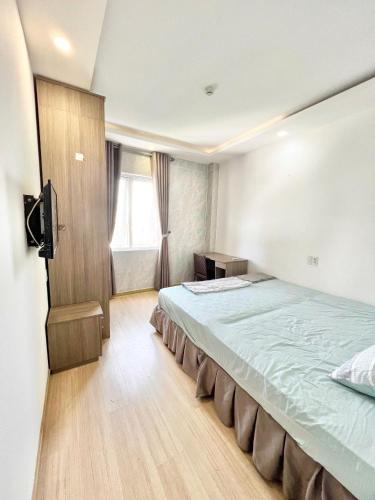a bedroom with a bed and a television in it at T-Home Apartment Hotel in Da Nang