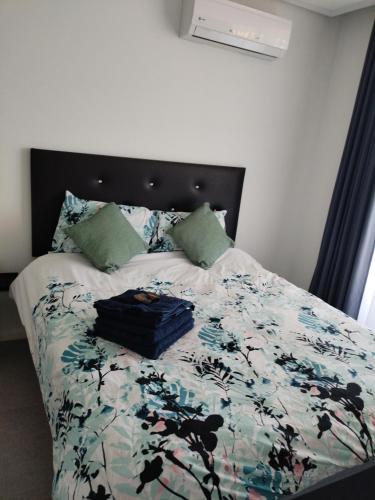 a bedroom with a bed with a floral comforter at Pebble Beach 204 in Sibaya