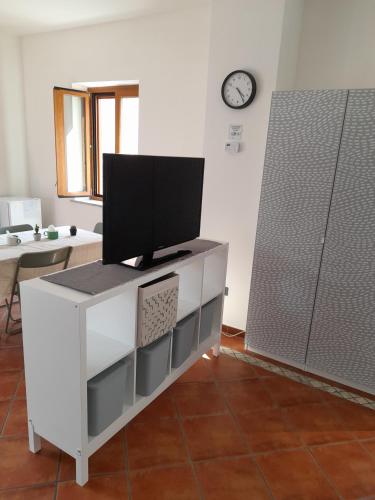 a living room with a tv on a white cabinet at B&B case rosse in Salerno