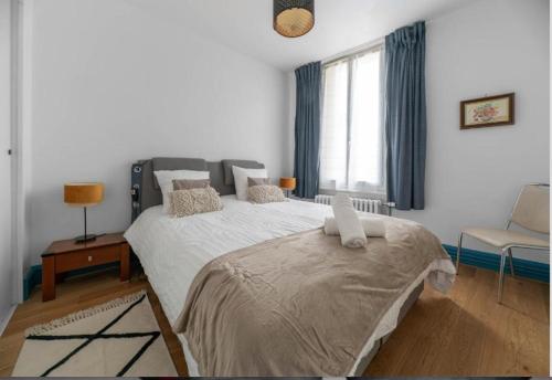 une chambre avec un grand lit et une chaise dans l'établissement LE DARCET - Hypercentre - Calme - Proche Gare & Thermes, à Vichy