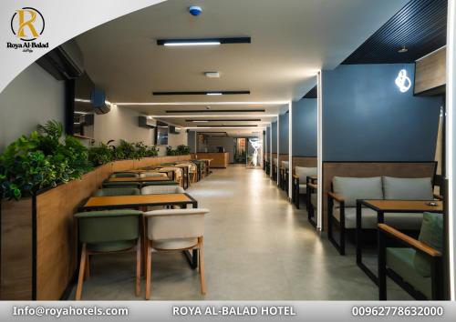 a restaurant with tables and chairs and a long corridor at Roya Downtown Boutique Hotel in Amman