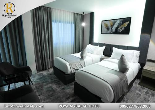 a hotel room with two beds and a chair at Roya Downtown Boutique Hotel in Amman