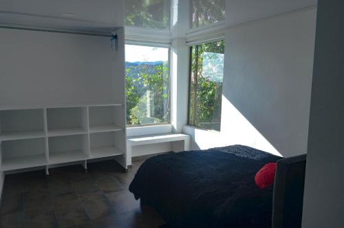 a bedroom with a bed and a large window at Dos Arcoiris Hospedaje Rural in Suesca