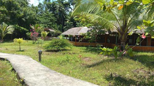 a path leading to a house in a garden at Lekker Gezellig Dive Resort Manado in Bunaken
