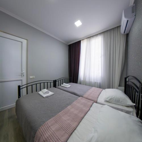 two beds in a hotel room with a window at Dimitris Cabin In surami in Surami