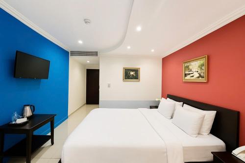 a bedroom with a white bed and a blue and red wall at La Bonita - Phu My Hung in Ho Chi Minh City