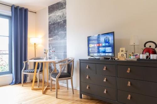 a bedroom with a dresser with a table and a tv at A l'Ombre d'Azay - Demeure d'Hôtes - GuestHouse in Azay-le-Rideau