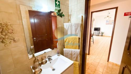 a bathroom with a sink and a mirror at Casa Tropical by Sunny Deluxe in Armação de Pêra