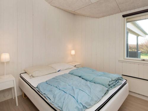 a white bedroom with a bed with blue sheets at 8 person holiday home in Børkop-By Traum in Egeskov