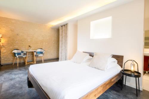 a bedroom with a bed and a table with chairs at A l'Ombre d'Azay - Demeure d'Hôtes - GuestHouse in Azay-le-Rideau