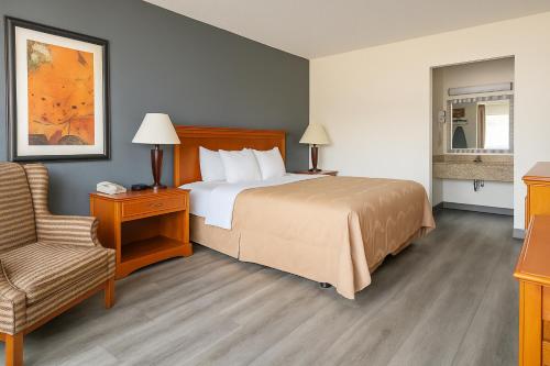 a hotel room with a bed and a chair at Quality Inn & Suites McDonough South I-75 in McDonough