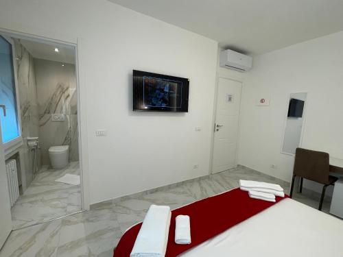 a white room with a red bed and a bathroom at Safa Venice Station in Mestre