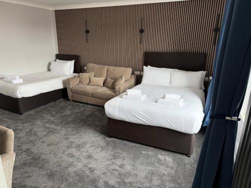 a hotel room with two beds and a couch at Thomas Arms Hotel in Llanelli