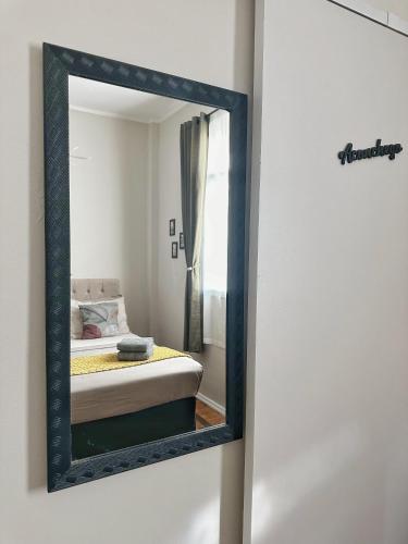 a mirror on a wall with a bed in a room at Hospedagem Inclusiva - Quarto privado com banheiro in Rio de Janeiro