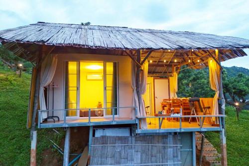 a small house with a thatched roof at Kirin Farm in Chiang Mai
