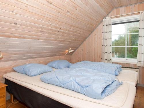 a bed in a room with a wooden wall at Luxury Retreat with Pool - By Traum Ferienwohnungen in Toftum