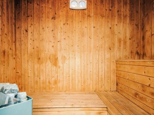 a room with a wooden wall with a clock on it at Luxury Retreat with Pool - By Traum Ferienwohnungen in Toftum