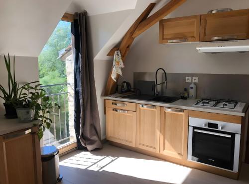 una cucina con fornelli, lavello e finestra di Appartement à l'Aujardière a Durtal