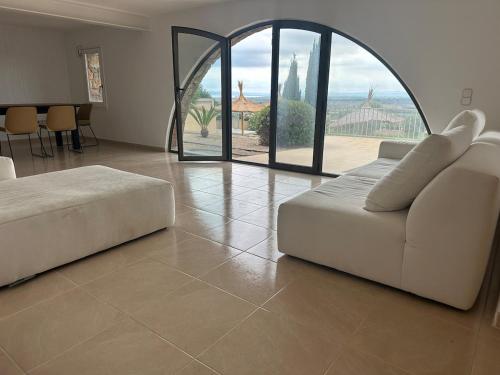 a living room with a couch and a large window at Can Gala - Appartment & Private Pool in Pau