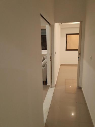 a hallway with white walls and a room with a bed at West end 1Bed Apart Rainha Ginga in Luanda