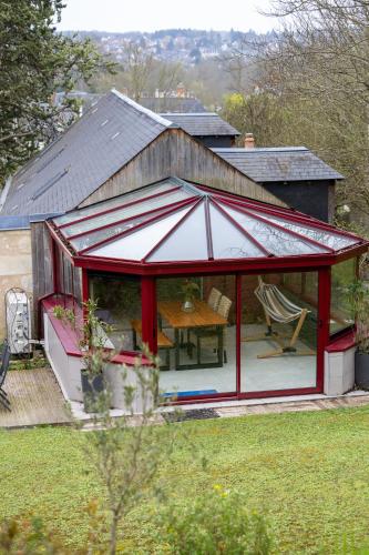 a red pavilion with a table in a backyard at A l'Ombre d'Azay - Demeure d'Hôtes - GuestHouse in Azay-le-Rideau