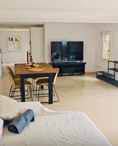 a living room with a table and a couch at Can Gala - Appartment & Private Pool in Pau