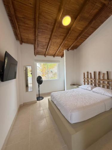 a bedroom with a large bed and a television at Hotel Puerto Antiguo in Los Órganos