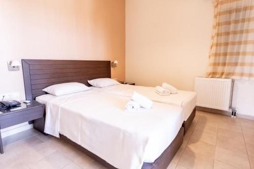 a bedroom with two beds with white sheets at Your Memories Hotel in Gouves