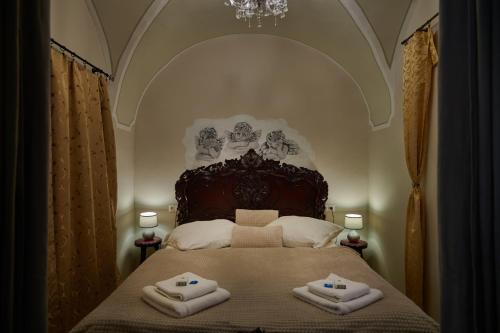 a bedroom with a large bed with two towels on it at Apartman Charlotte v Dome so studňou na streche in Banská Štiavnica