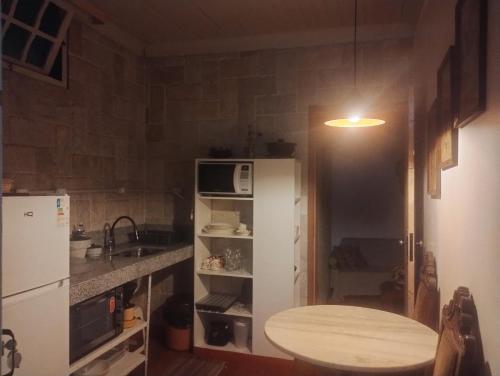 a kitchen with a white refrigerator and a sink at APARTAMENTOS ALTOS DA GRUPIARA - DIAMANTINA/MG in Diamantina