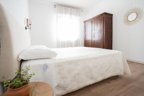 a white bedroom with a bed and a window at Trilocale con piscina in Caprino Veronese