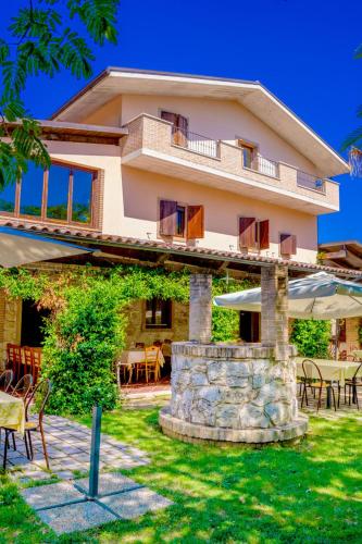 a large house with tables and chairs in front of it at Country House Il Piacere in Civitella del Tronto