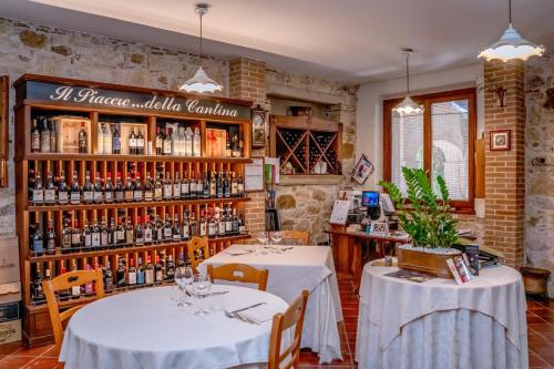 a restaurant with two tables and a shelf of wine bottles at Country House Il Piacere in Civitella del Tronto