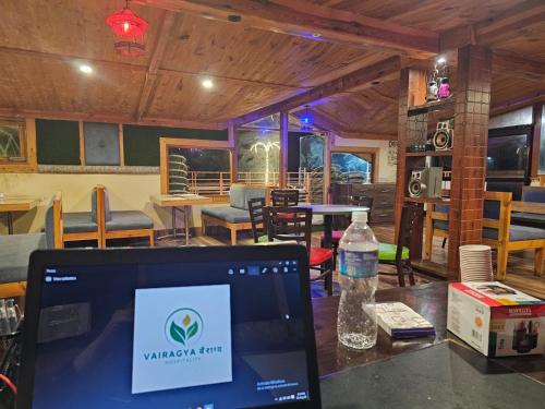 a laptop computer sitting on a table in a restaurant at Green Valley Waknaghat by Vairagya Hospitality in Kandāghāt