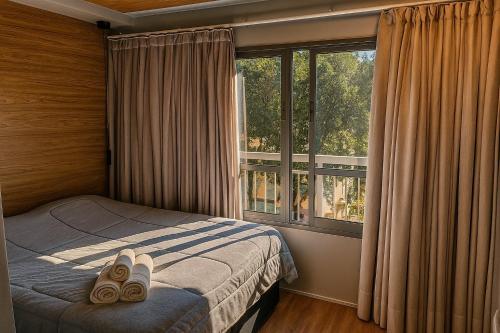 a bedroom with a bed and a large window at Apartamento Aconchegante na Vila Mariana in Sao Paulo