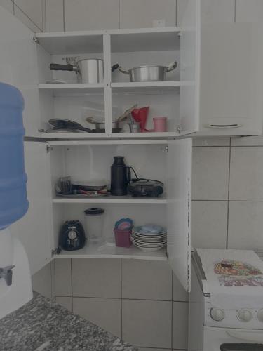 a kitchen with white shelves with dishes on them at Casa Progresso em Anápolis in Anápolis