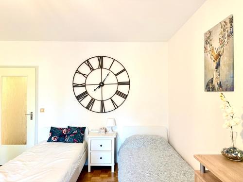 a bedroom with a bed and a clock on the wall at Welcome to Messe! Two-bedroom SmartApartment &Balcony in Hannover