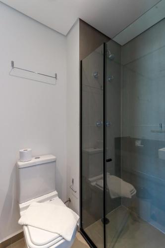 a bathroom with a toilet and a glass shower at 360 VN Turiassú by Housi in Sao Paulo