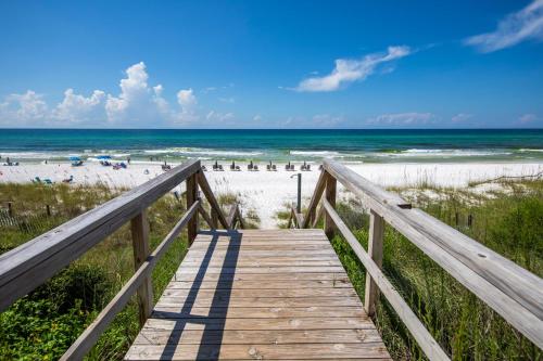 a wooden boardwalk to the beach with the ocean at Whispering Sands 1A in Coffeyville