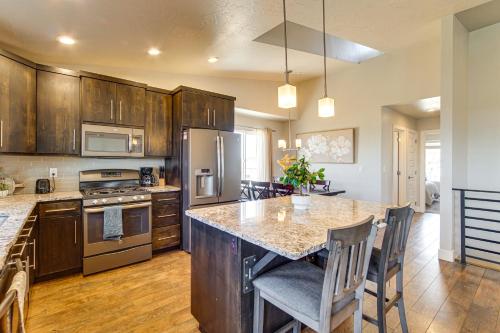 a kitchen with wooden cabinets and a island with a counter top at Panoramic Views Spacious Home in Cedar City! in Cedar City