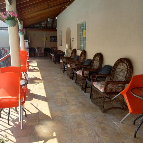 a row of chairs and tables in a waiting room at Pousada Parque Suites - Estacionamento e Piscina in Guarujá