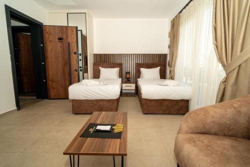 a hotel room with two beds and a coffee table at Crown Salamis Hotel in Mağusa