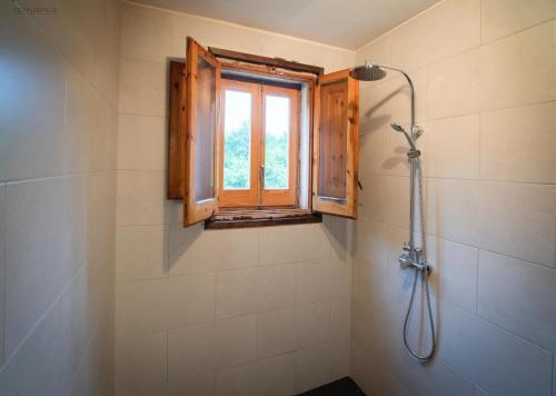 a bathroom with a shower and a window at Masia Can Felix Santa Fe in Barcelona