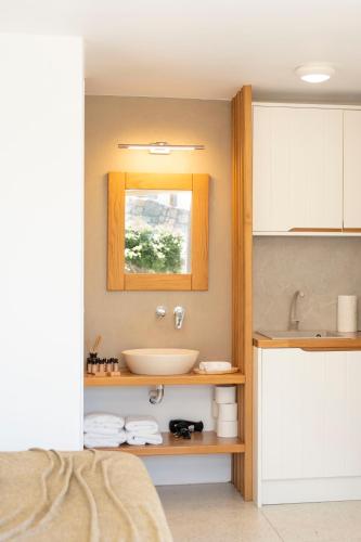 a bathroom with a sink and a mirror at Due Mari Mykonos in Agios Ioannis Mykonos